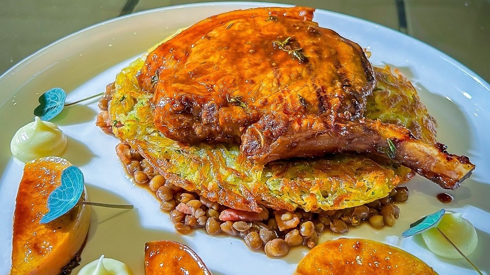 Chop de porc glacée grillée de Neven avec rosti, pommes caramélisées et lentilles balsamiques