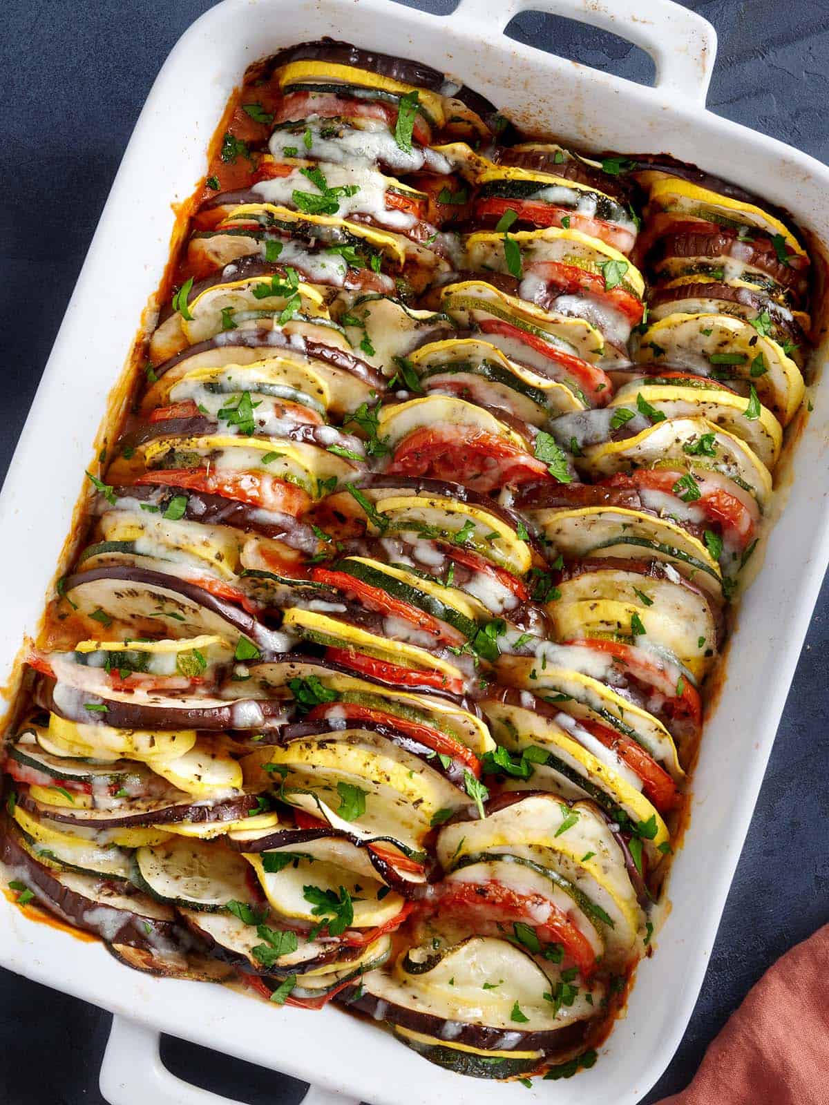 Vue aérienne d'un plat allant au four rempli de couches de ratatouille rôtie au four.