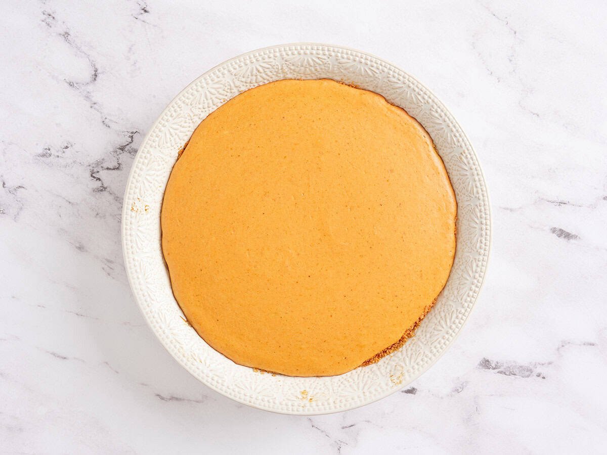 Cheesecake à la citrouille cuit au four dans un plat à tarte.