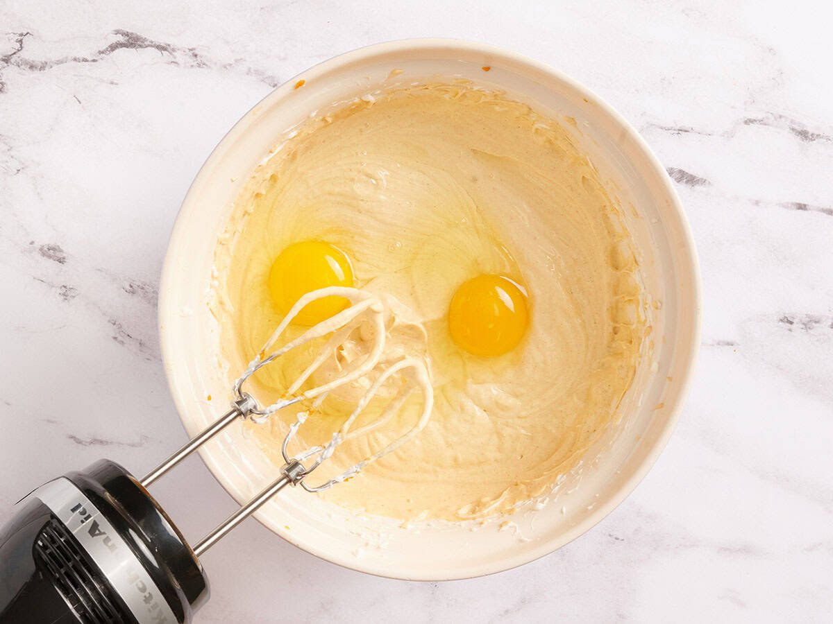 Œufs ajoutés au cheesecake à la citrouille remplissant un bol.