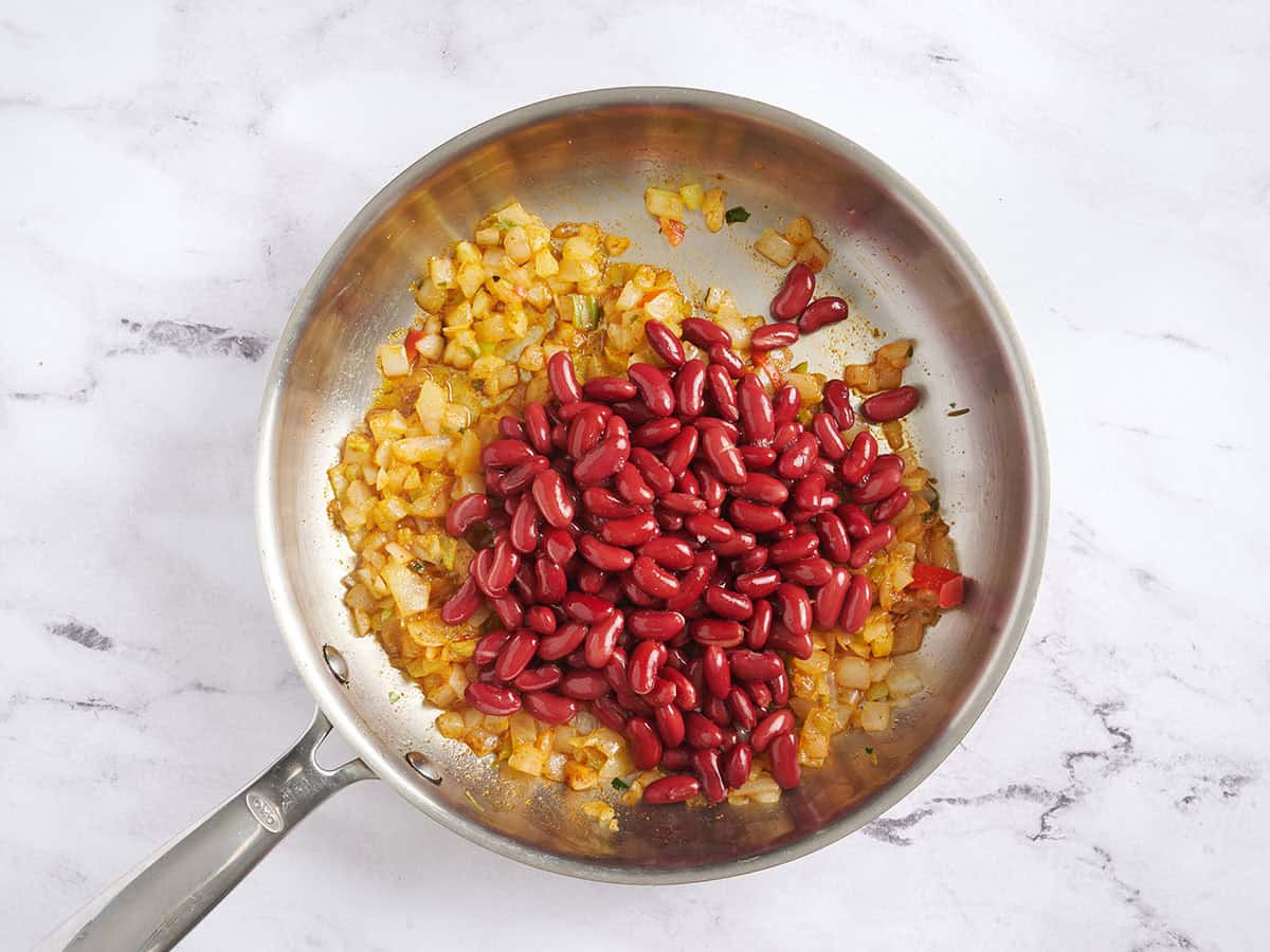 Mélange de légumes et haricots rouges dans une poêle.