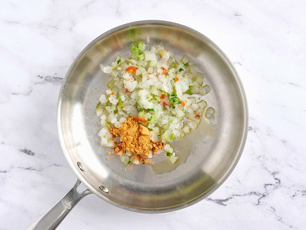 Légumes mélangés surgelés et assaisonnement pour tacos dans une poêle.