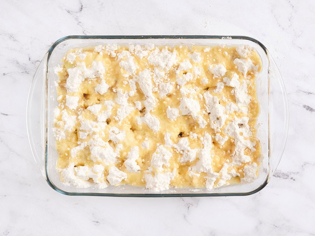 Un gâteau aux pommes dans un plat allant au four avant la cuisson.