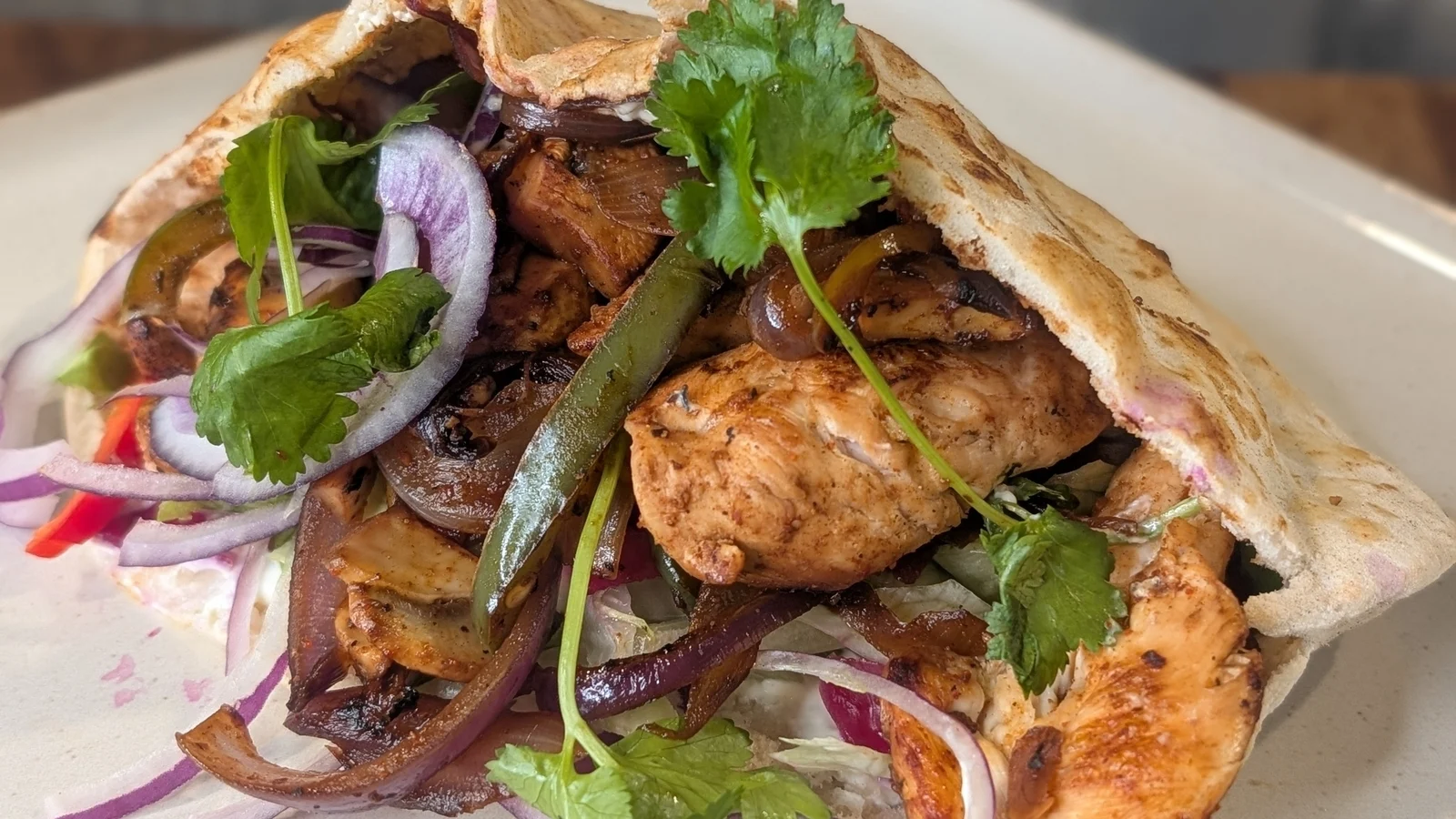 Pitta au poulet cajun de Trisha avec yaourt à la menthe et légumes râpés