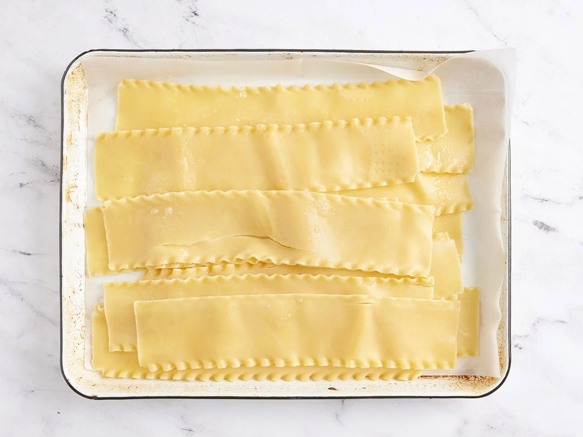 Nouilles de lasagne cuites sur une plaque à pâtisserie.