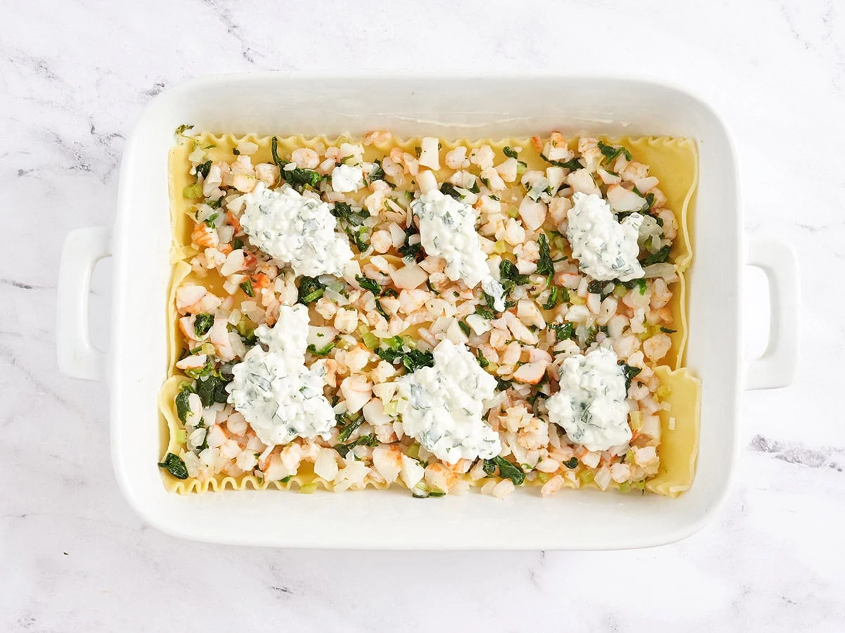 Couche de fruits de mer et de fromage cottage ajoutée.