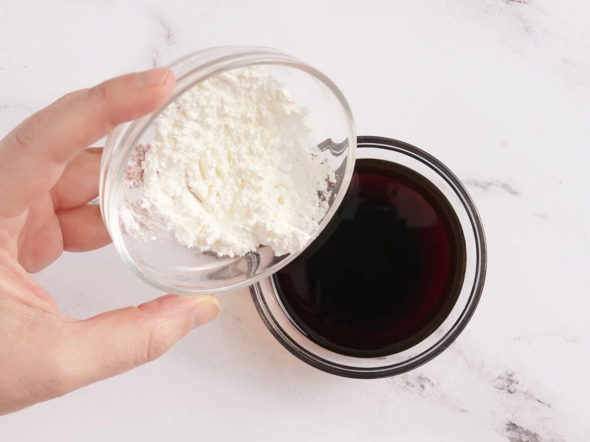 La fécule de maïs est versée dans la sauce soja.