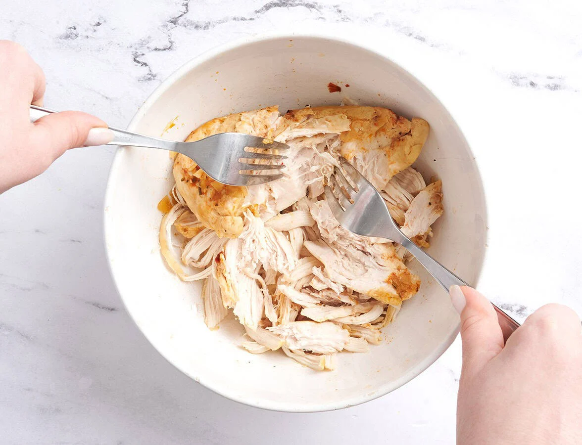 déchiqueter le poulet avec deux fourchettes pour la soupe au poulet 