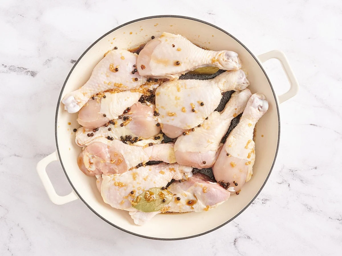 Pilons de poulet recouverts d'une marinade dans une casserole.