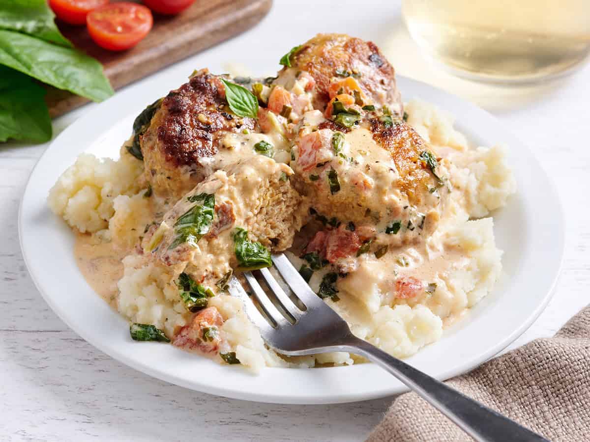 Side view of marry meatballs on a plate with mashed potates.