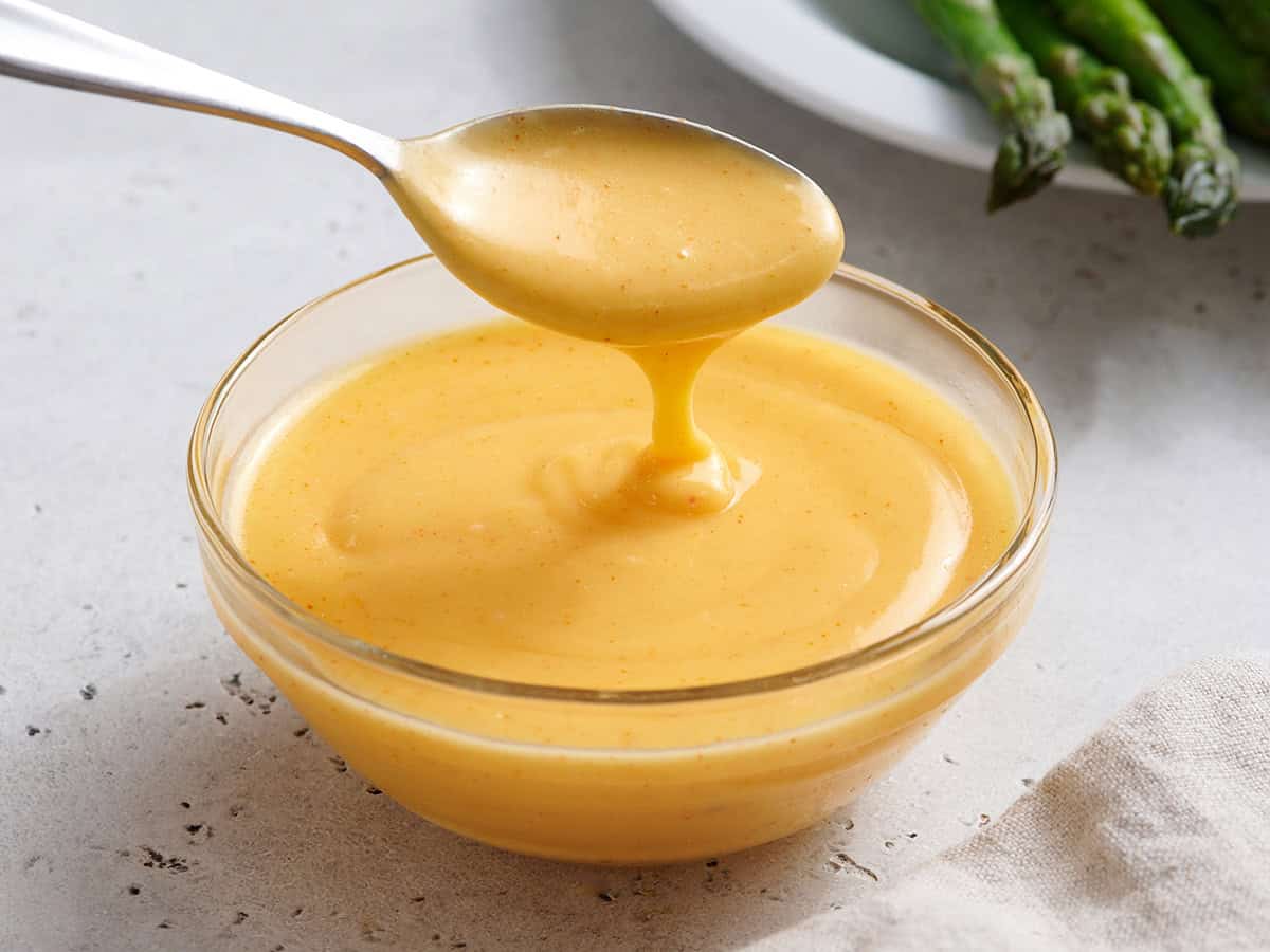 Sauce hollandaise maison dans un bol avec une cuillère.