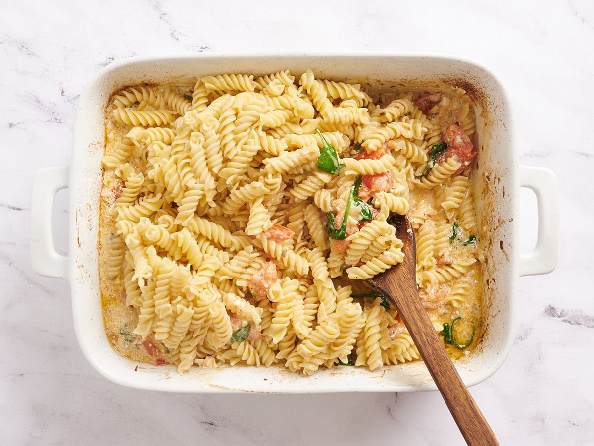 Pâtes rotini mélangées à des tomates rôties, des oignons et du fromage feta.