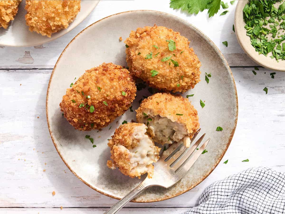 Vue aérienne de croquettes de poulet sur une assiette dont une coupée en deux.