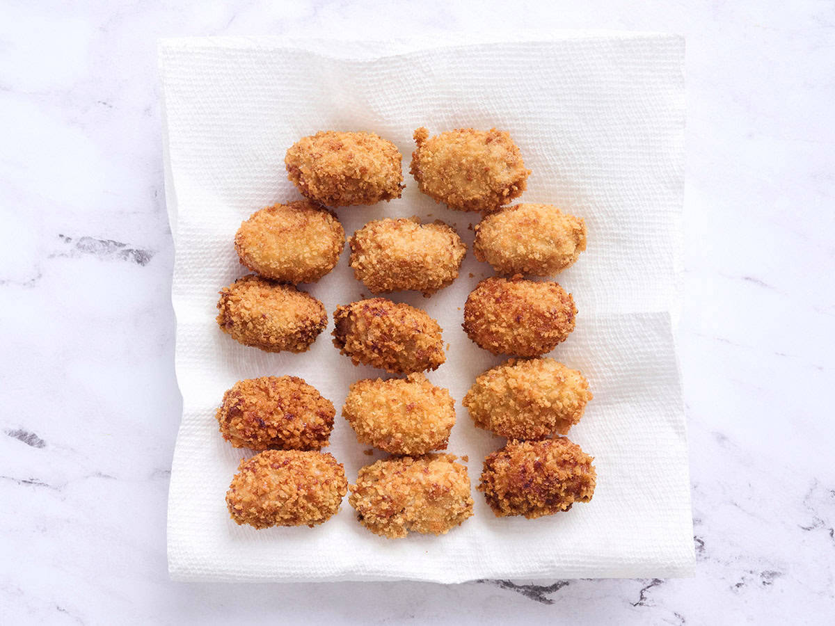 Croquettes de poulet finies sur une serviette en papier.