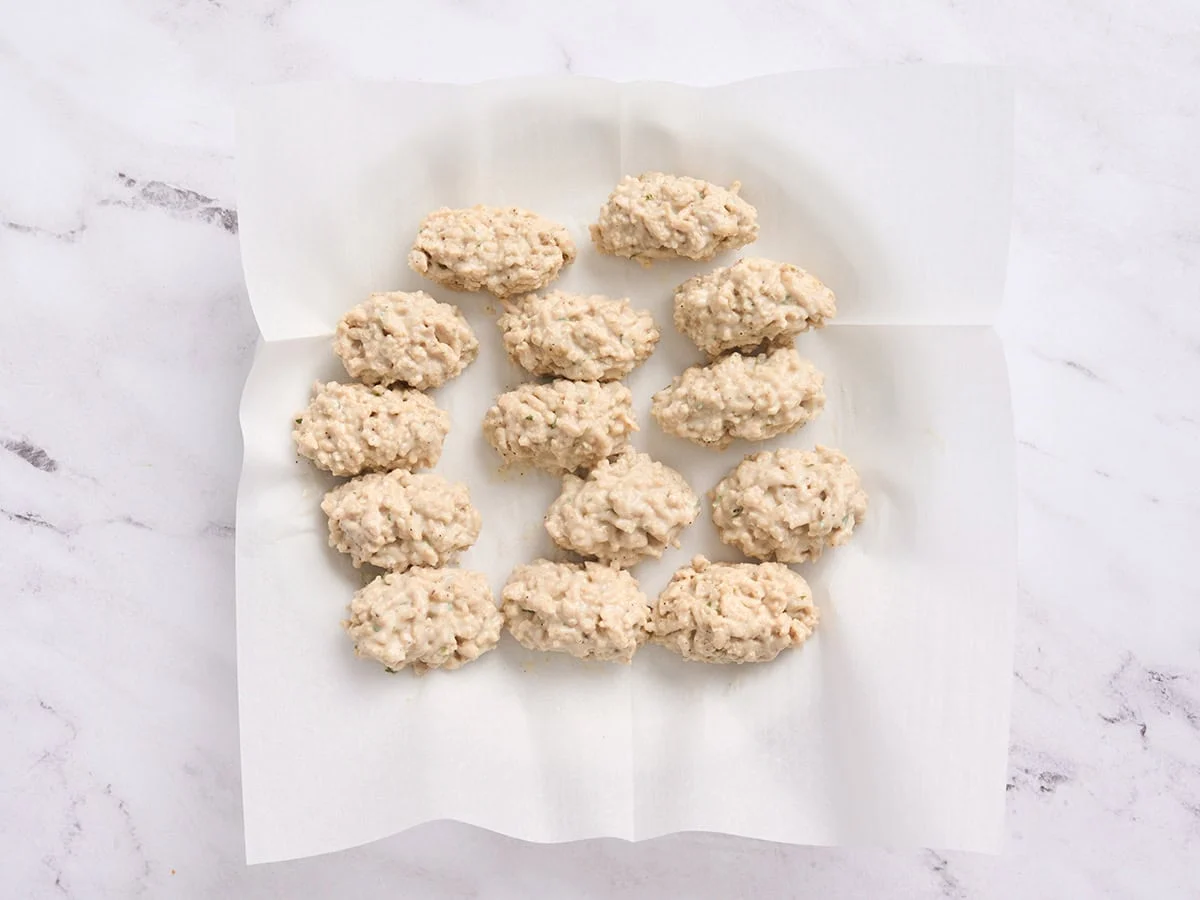 Croquettes de poulet formées sur une assiette.