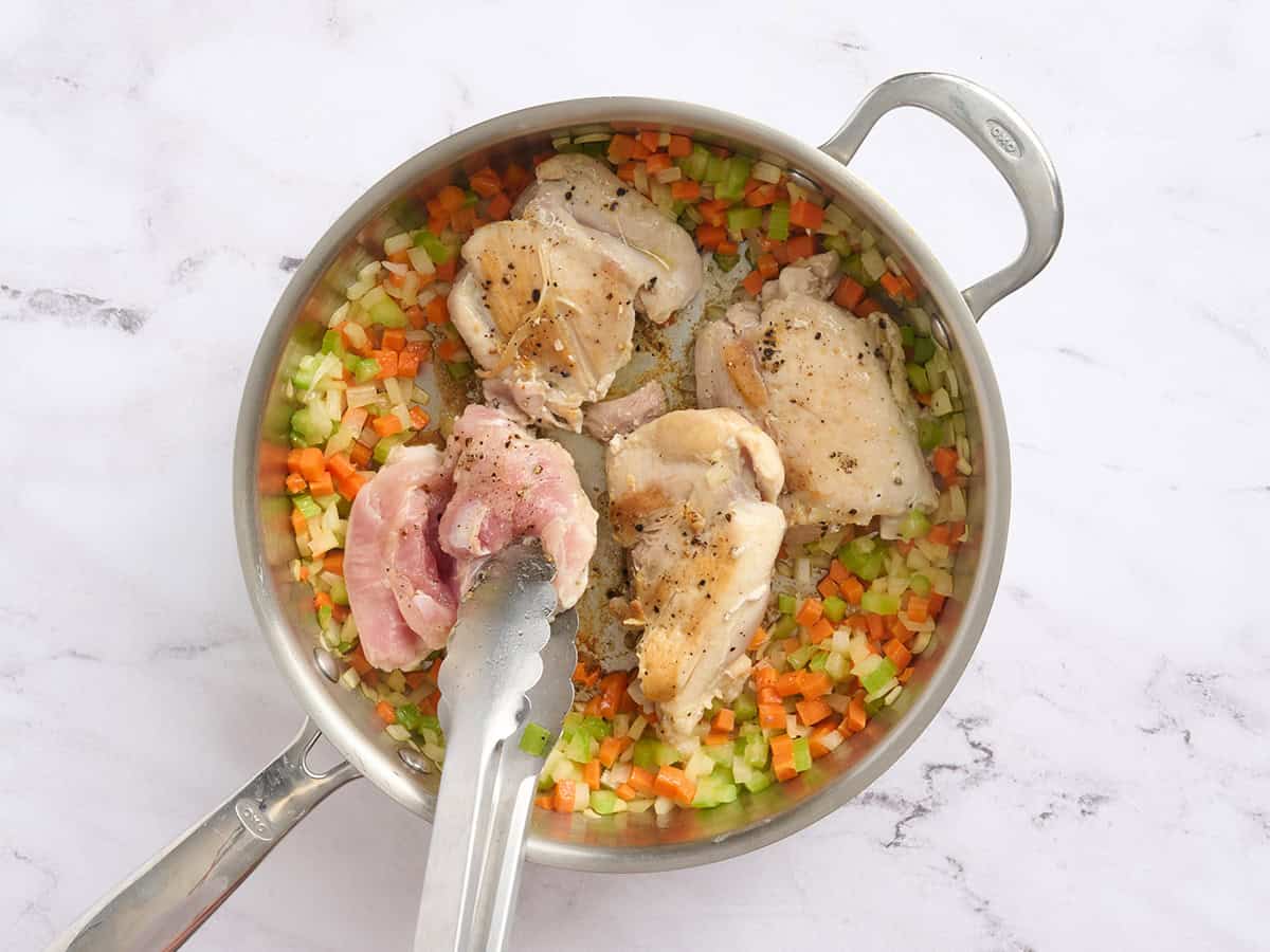 Cuisses de poulet cuites à la poêle avec de la mirepoix.