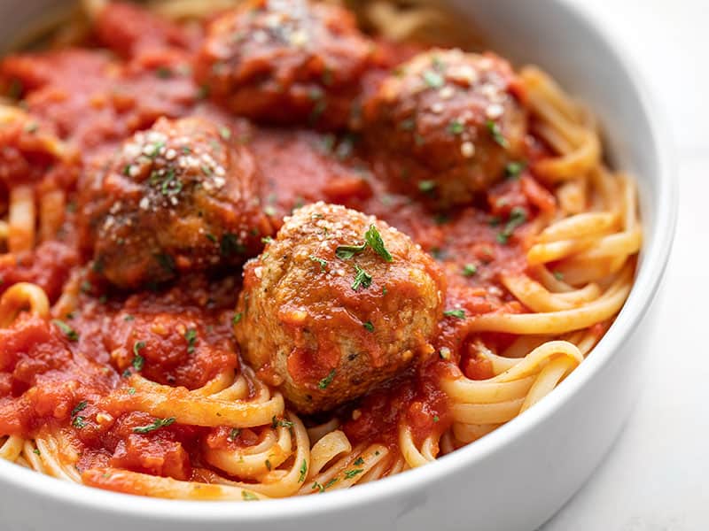 Vue rapprochée de boulettes de poulet au parmesan sur un tas de spaghetti avec sauce