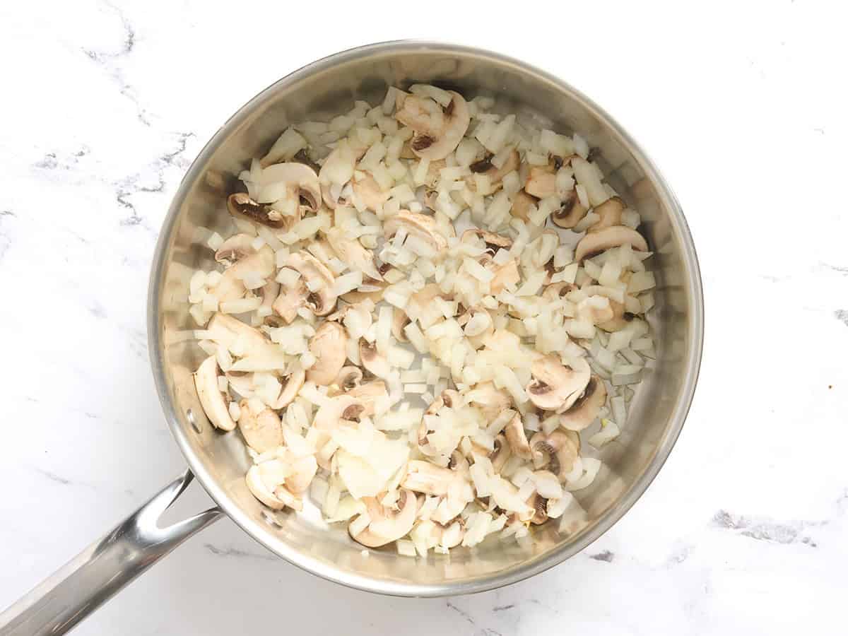 Champignons et oignons dans une poêle.