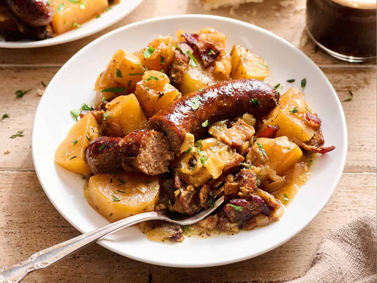 Side view of Dublin coddle on a plate with a fork.