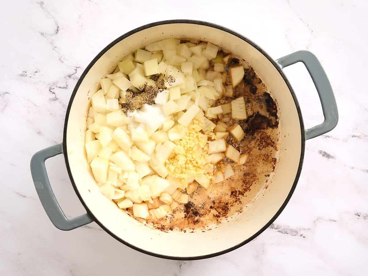 Cuisson de l'oignon et des assaisonnements dans une cocotte.