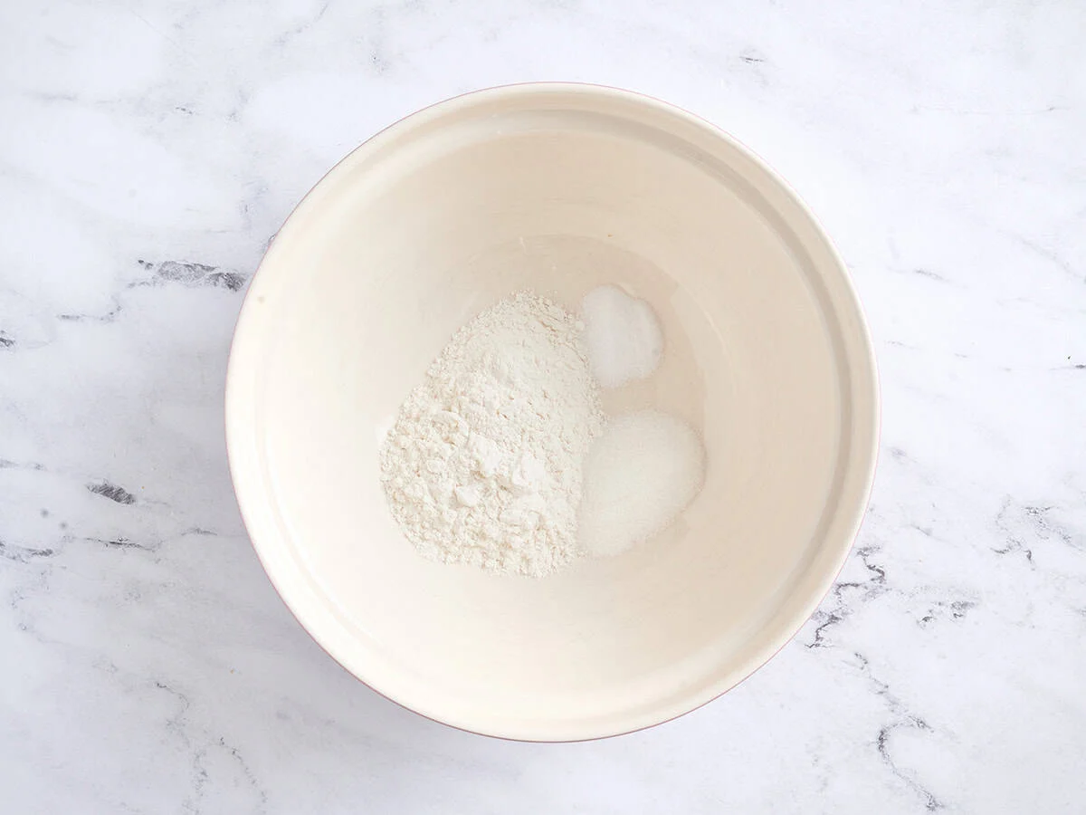Farine, sel et sucre dans un bol blanc.