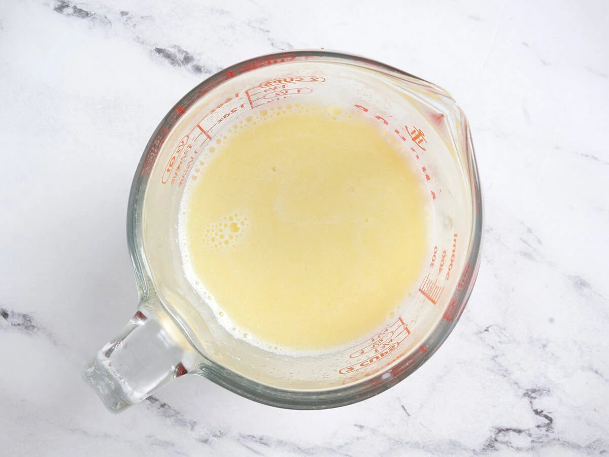 Faire fondre le beurre et réchauffer le lait dans une tasse à mesurer en verre.