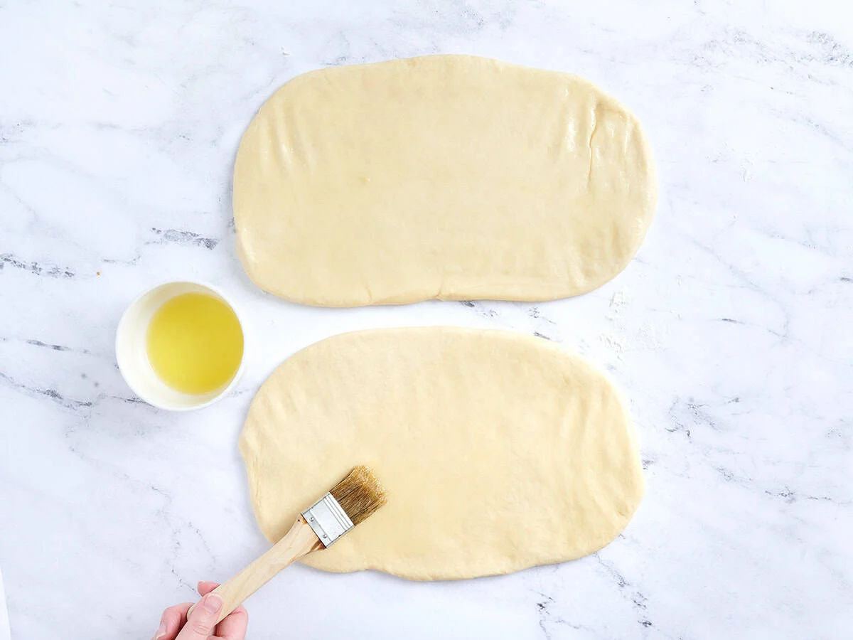 Badigeonner la pâte étalée de beurre.