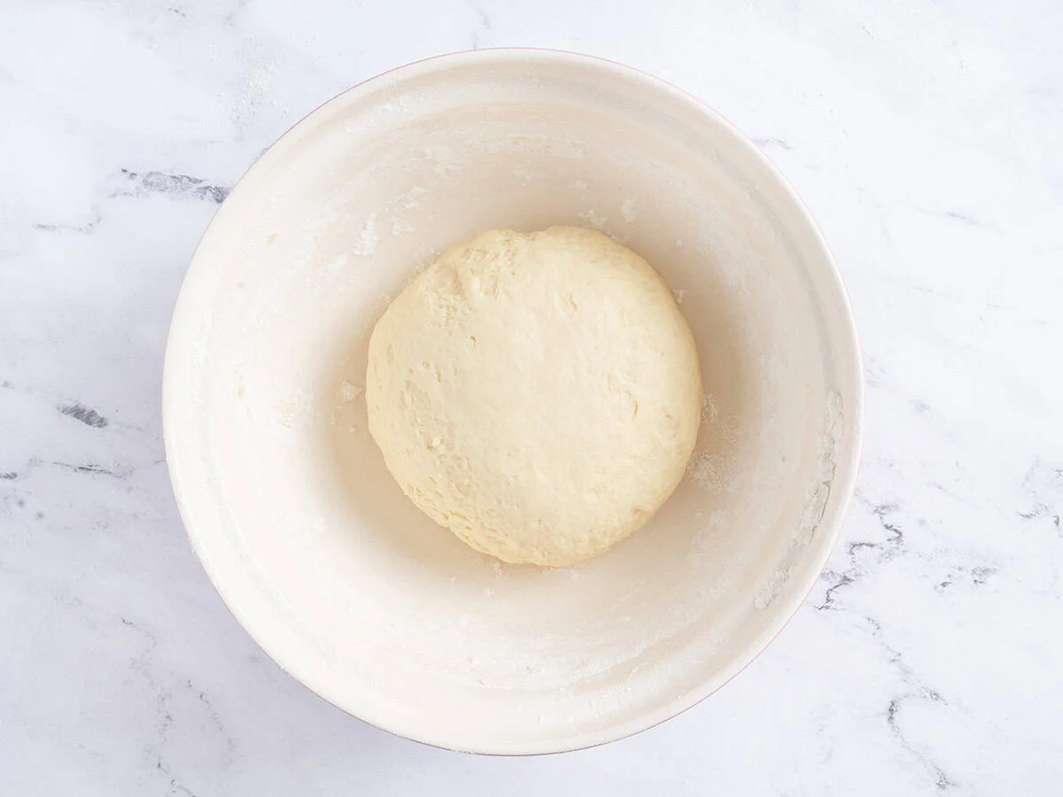 Boule de pâte dans un bol blanc juste avant de lever. 