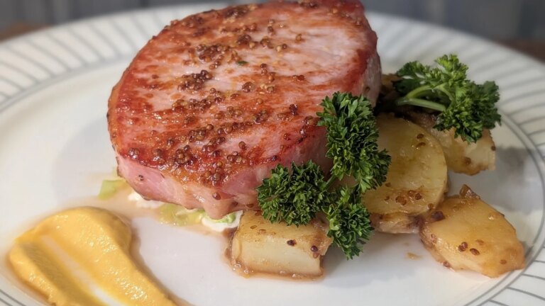 Côtelette de bacon glacée rôtie de Trisha avec chou de Savoie braisé, sauce à la crème moutarde et pommes de terre grelots au beurre