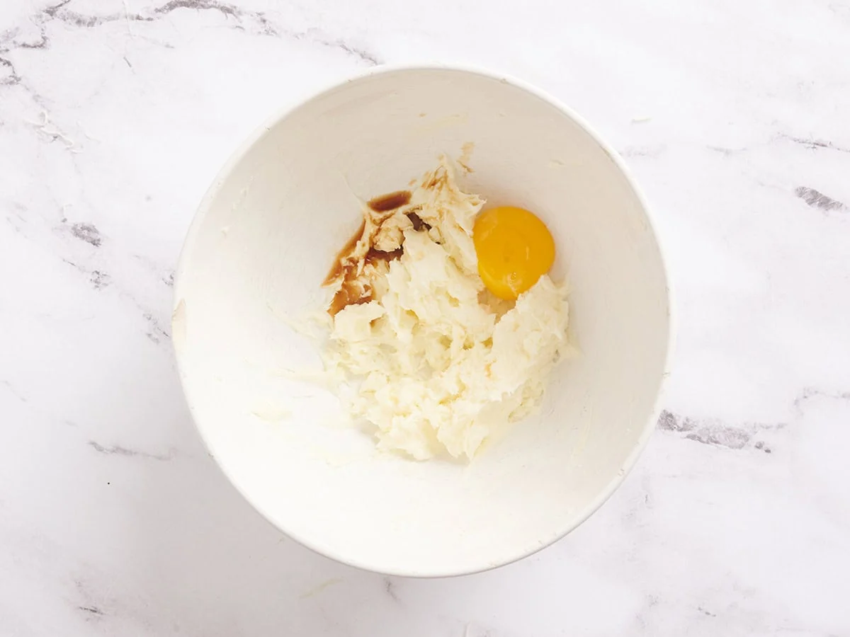 Un jaune d'œuf ajouté au mélange de cheesecake pour les barres de gâteau aux carottes.