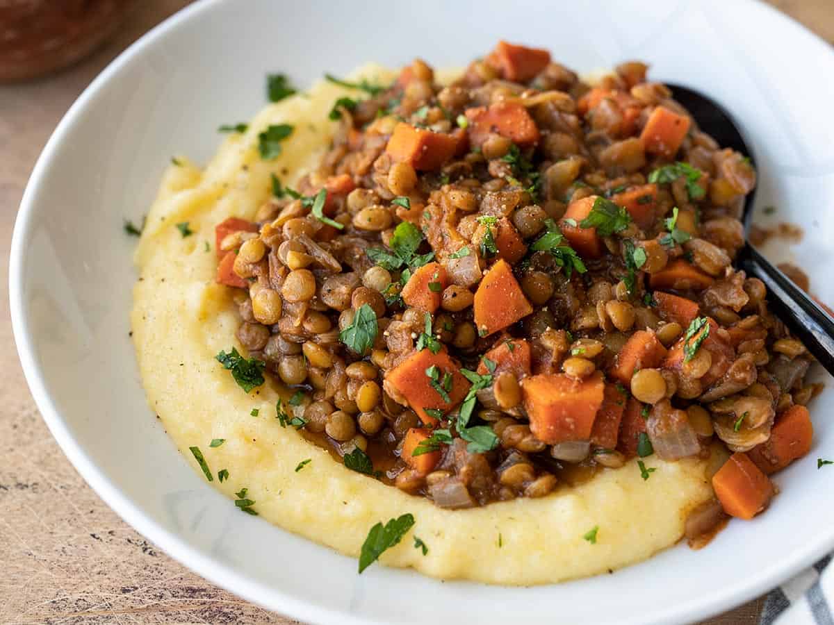 vue latérale des lentilles épicées sur un lit de polenta