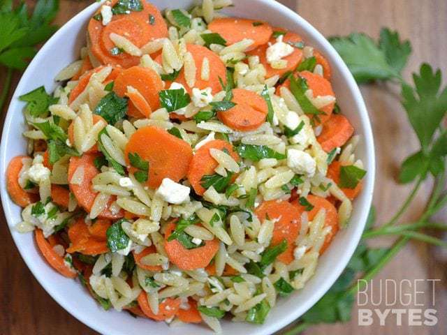Salade de carottes et orzo garnie d'herbes.