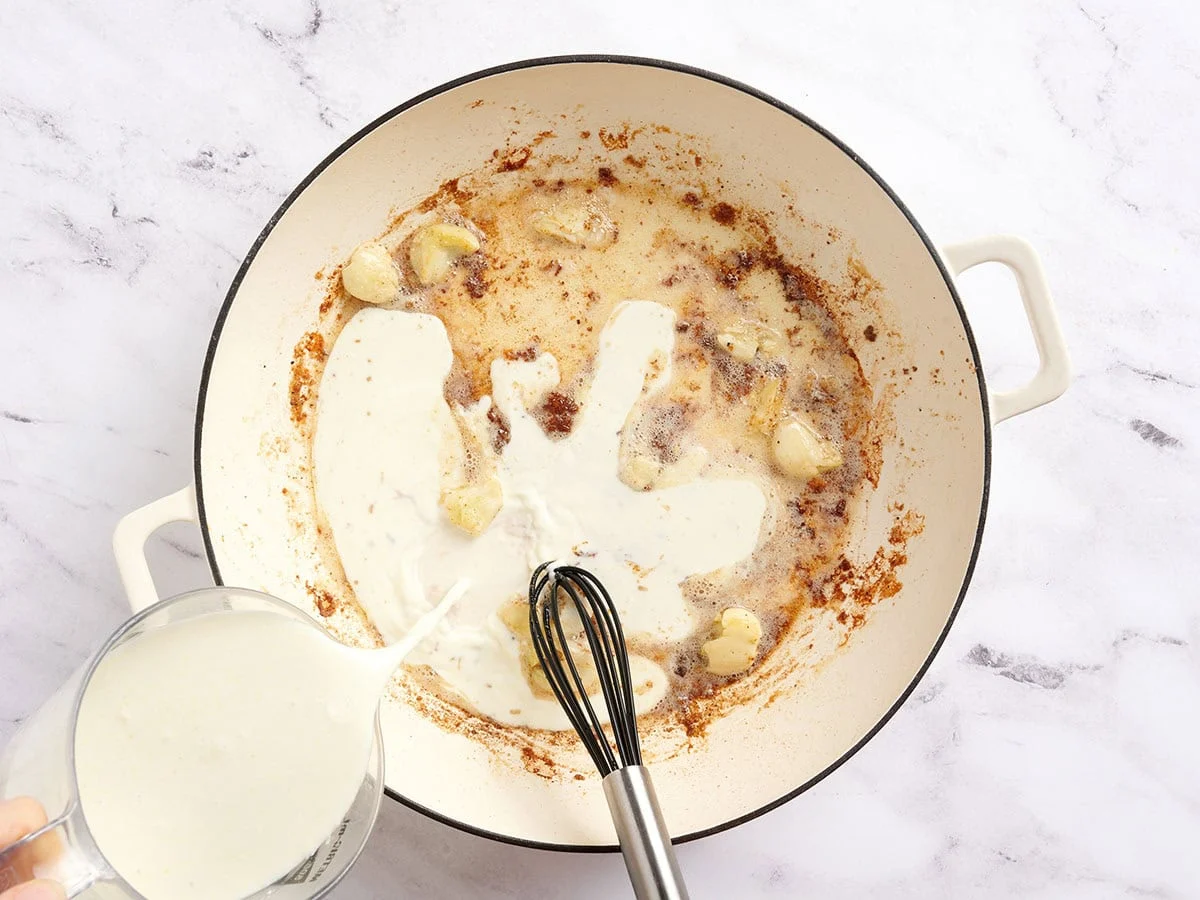 Crème épaisse versée dans une poêle.