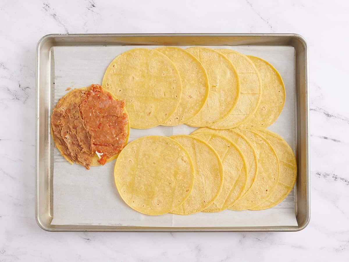 Haricots frits ajoutés à l'autre moitié d'une tortilla à côté d'un mélange de viande de dinde.