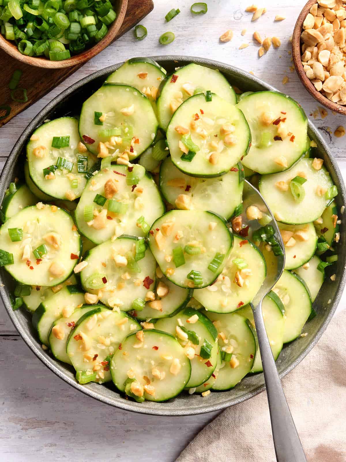 Vue aérienne d'un bol de salade de concombre au sésame avec une cuillère.