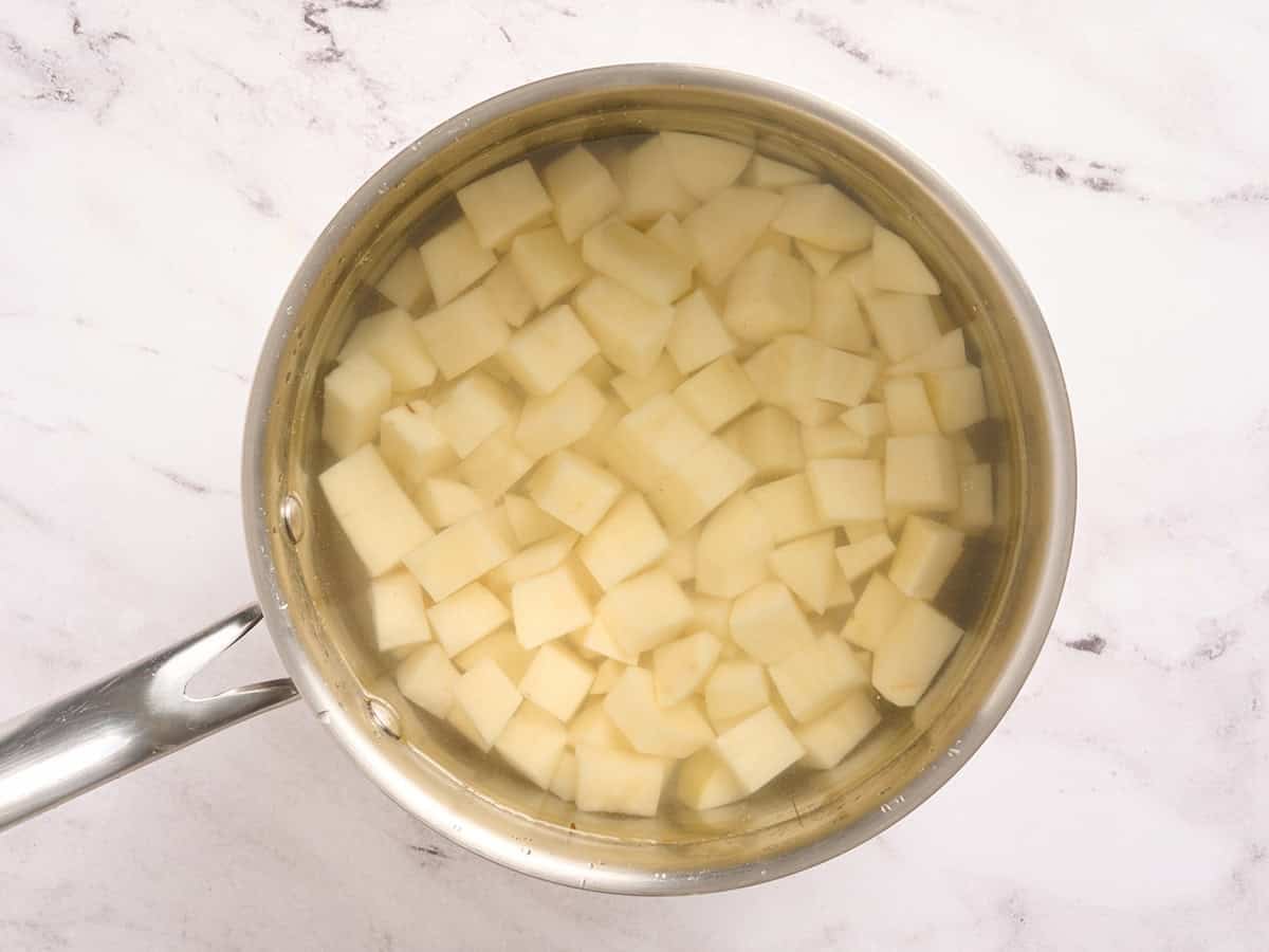 Pommes de terre coupées en dés dans une casserole d'eau.