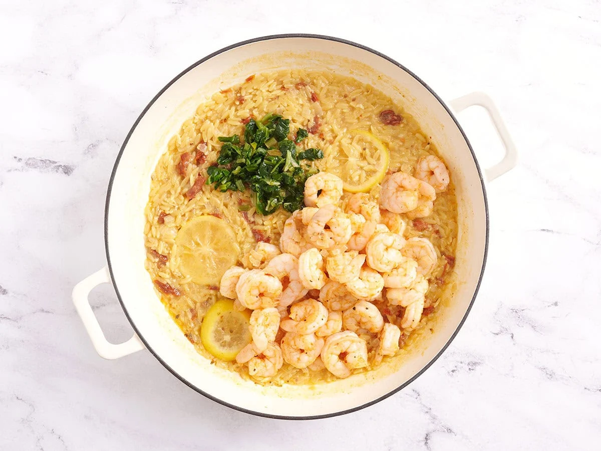 Crevettes et persil dans une poêle avec de l'orzo.