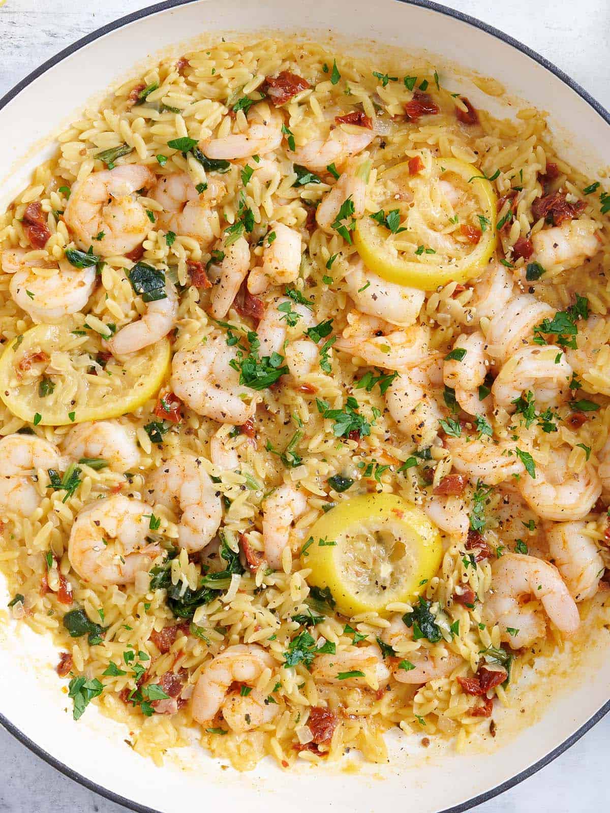 Vue aérienne d'une poêle à crevettes à l'ail et à l'orzo.
