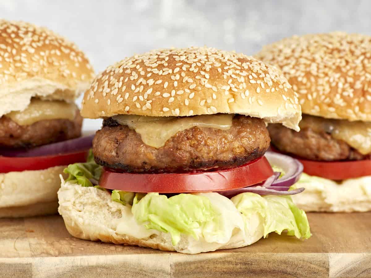 vue latérale des hamburgers de dinde garnis de fromage, de laitue et de tomates sur des petits pains.