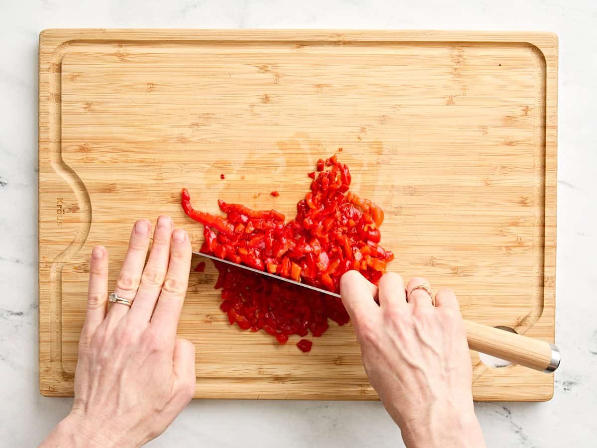 Mains à l'aide d'un couteau pour émincer les piments.