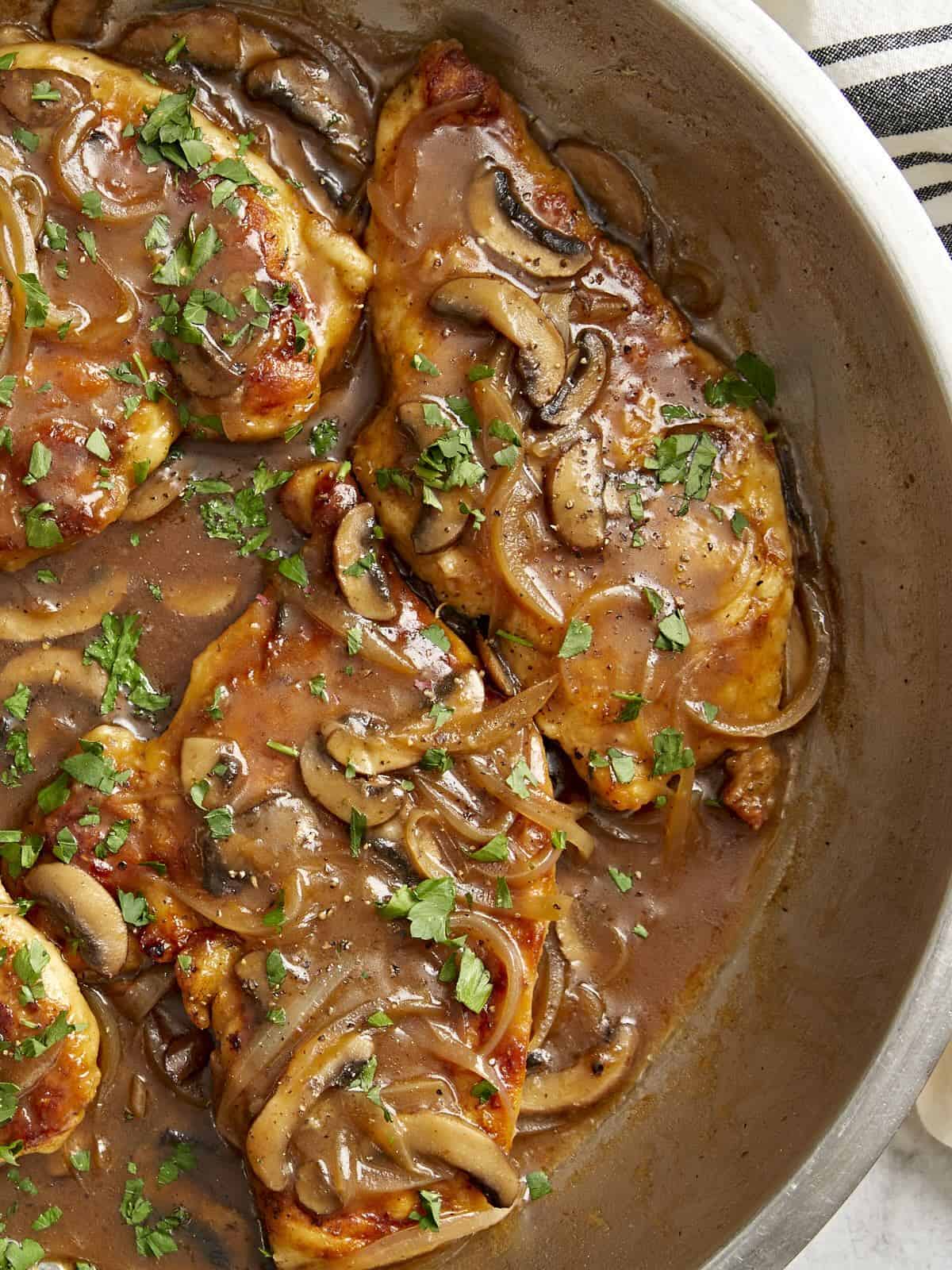vue partielle du dessus du poulet marsala dans une poêle.