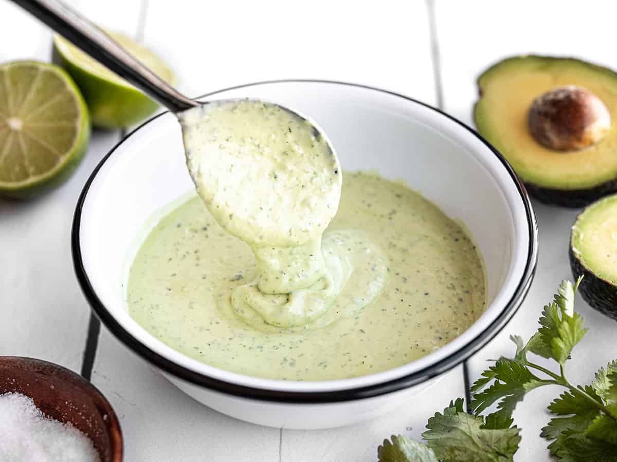 Vinaigrette crémeuse à l'avocat dégoulinant d'une cuillère dans un bol