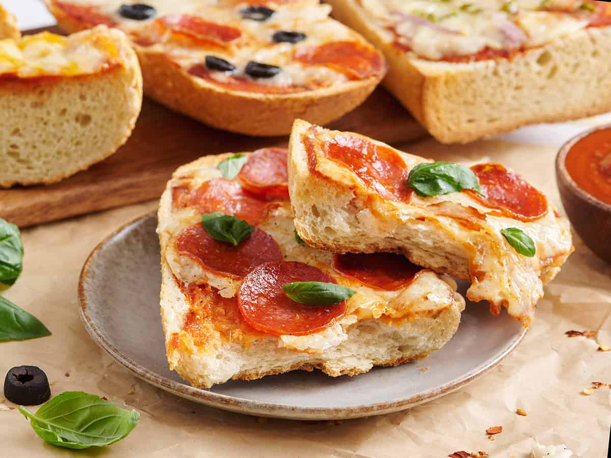 Side view of a pepperoni French bread pizza sliced in half.