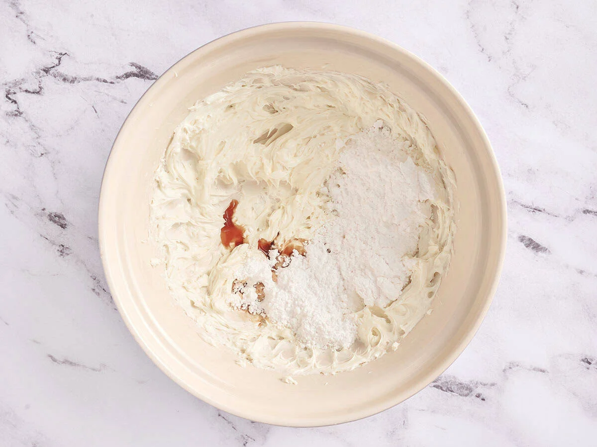 Fromage à la crème, vanille et sucre en poudre dans un bol.