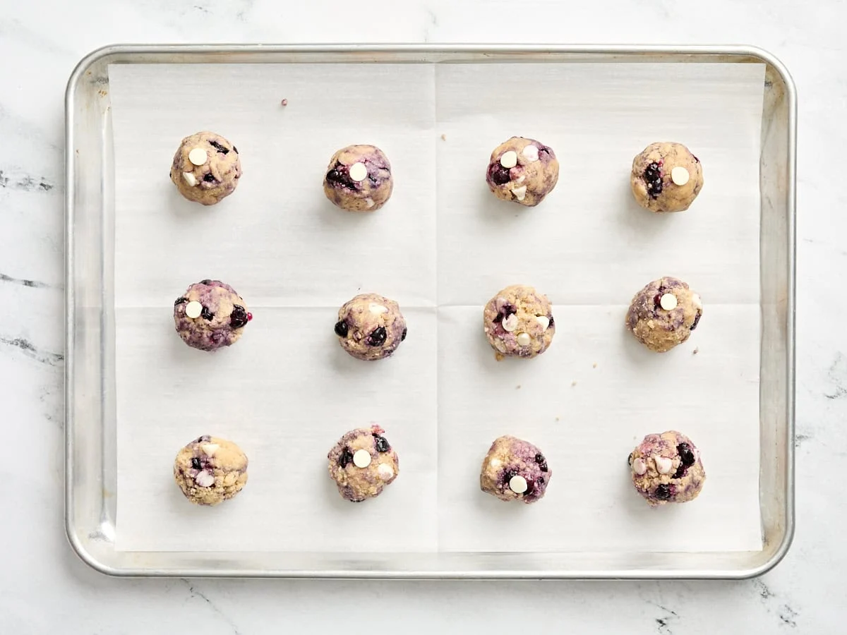 Boules de pâte à biscuits sur une plaque à pâtisserie.