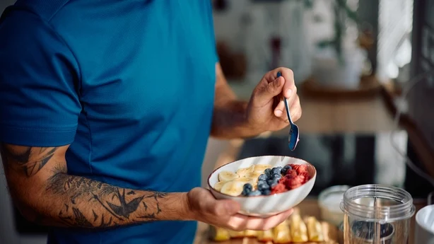 Gros plan sur un homme prenant un petit-déjeuner sain dans la cuisine.