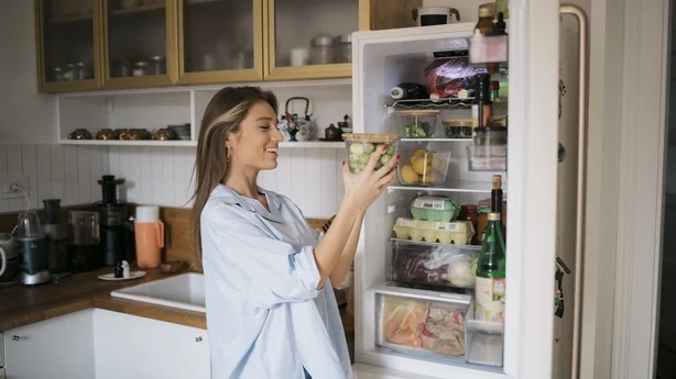 femme sortant de la nourriture du réfrigérateur