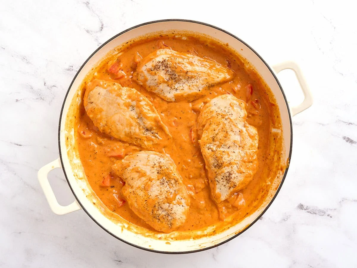 Poulet ajouté à une poêle de sauce tomate crémeuse.