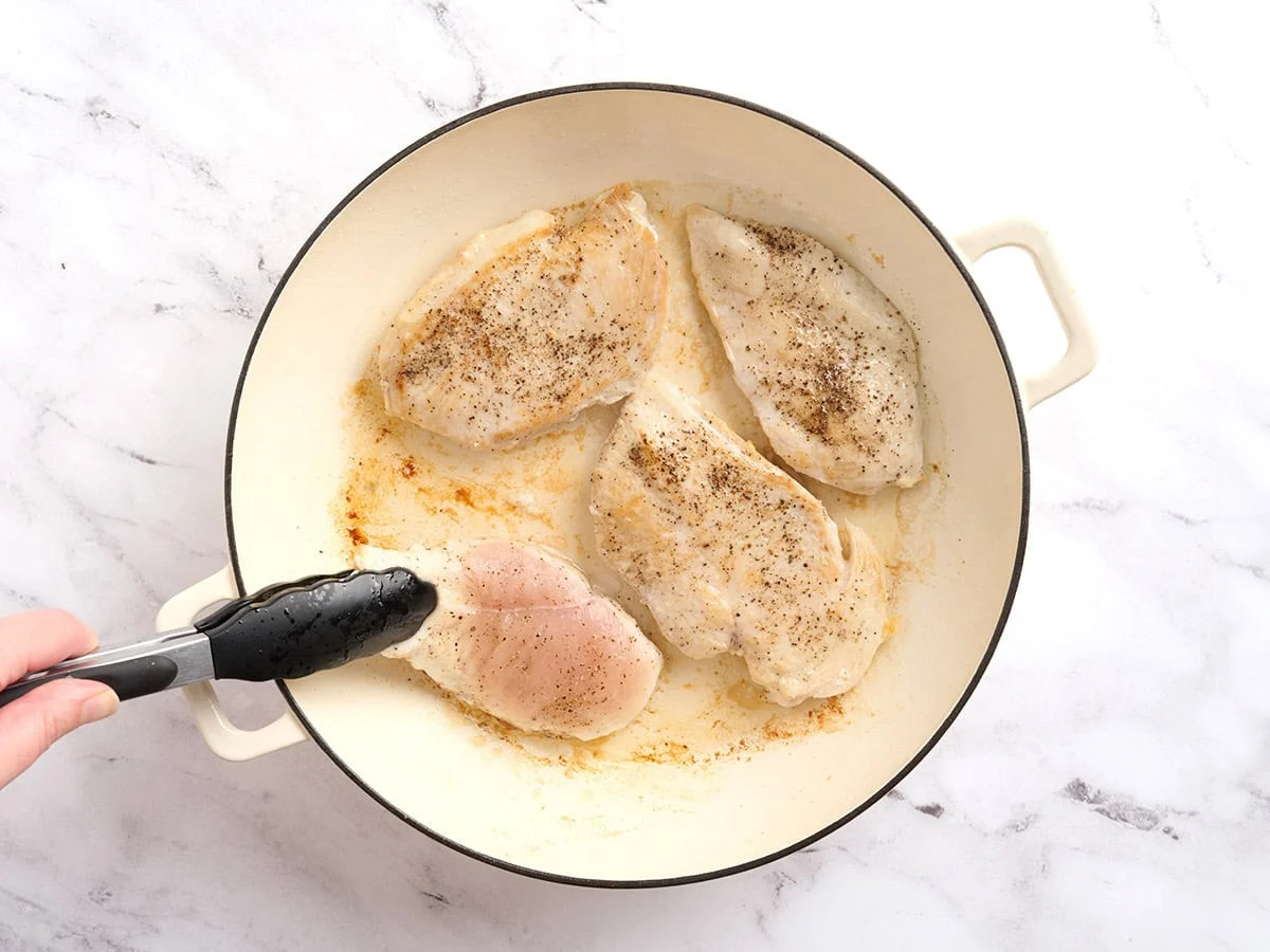 Filets de poulet saisis dans une poêle.