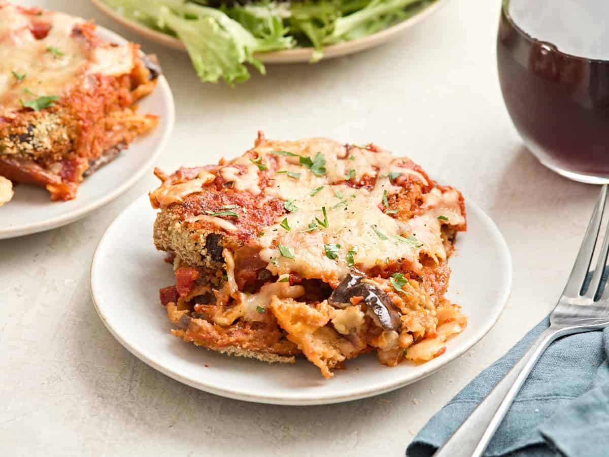Vue latérale d'une tranche d'aubergine parmesan sur une assiette.